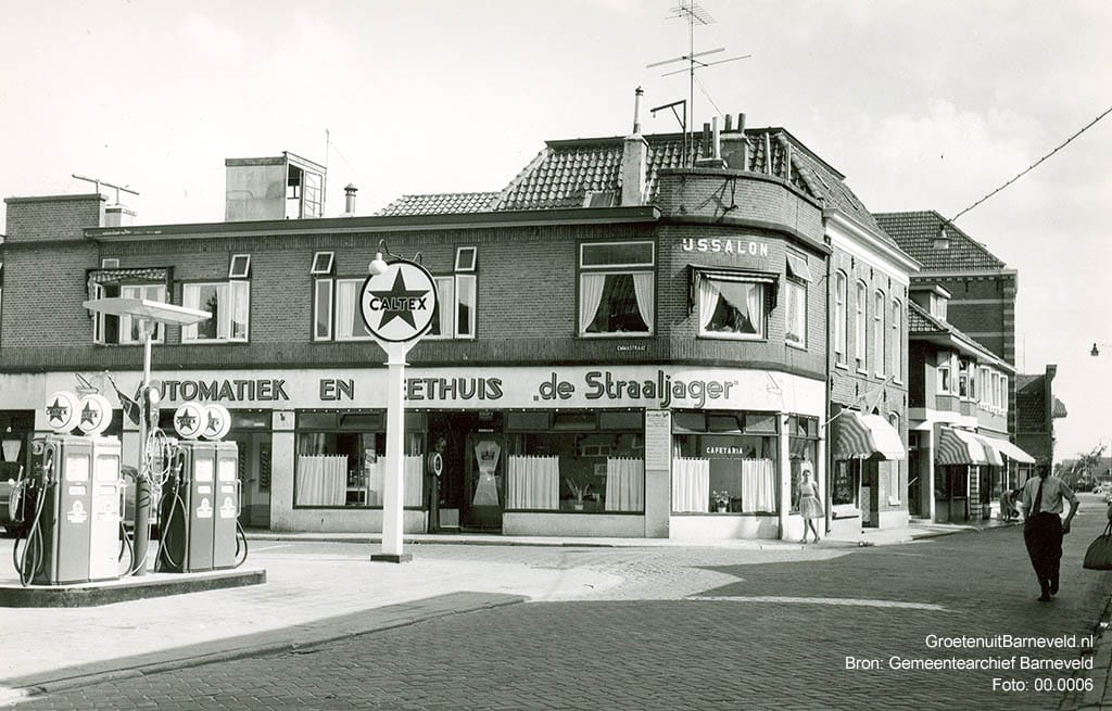 Verleden 1960 - De Langstraat met linksvoor Caltex benzinepomp van Garage Stronks, daarachter automatiek en eethuis de Straaljager - Barneveld