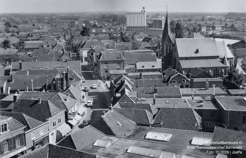 Verleden,1965 Rechts de toren van de Rooms Katholieke Catharinakerk. Op de achtergrond de silo van meelfabriek De Heus. - Barneveld