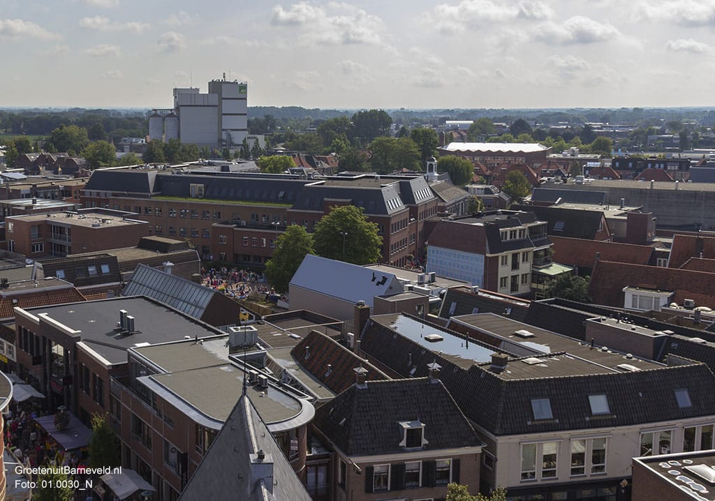 Heden, 2014 - Op de voorgrond de hoek Jan van Schaffelaarstraat / Langstraat. In het midden het Gemeentehuis. Rechtsachter (witte dak) het kerkgebouw van de Gereformeerde Gemeente Barneveld Centrum. Op de achtergrond de silo's van AgruniekRijnvallei. - Barneveld