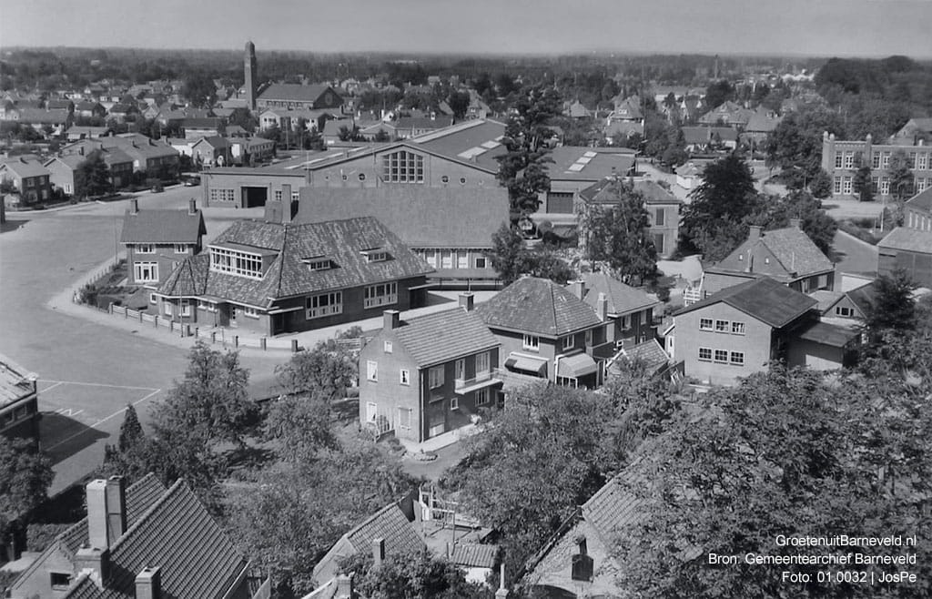 Verleden, 1965 - Foto vanaf de toren van de Oude Kerk. In het midden het Marktcomplex en gebouw Rehoboth. Rechts een stukje van de voormalige Prinses Julianaschool. - Barneveld