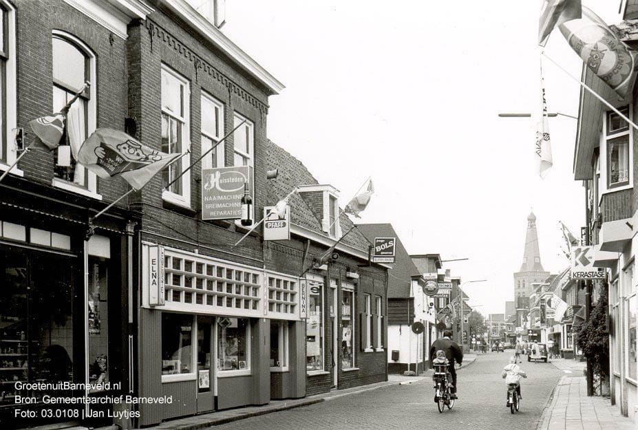Verleden 1980/1990 - Langstraat met van links naar rechts: slagerij Hardon, Huissteden naaimachinehandel, slijterij Erkens, cafetaria De Straaljager. Rechts Egbert's Hairshop. - Barneveld