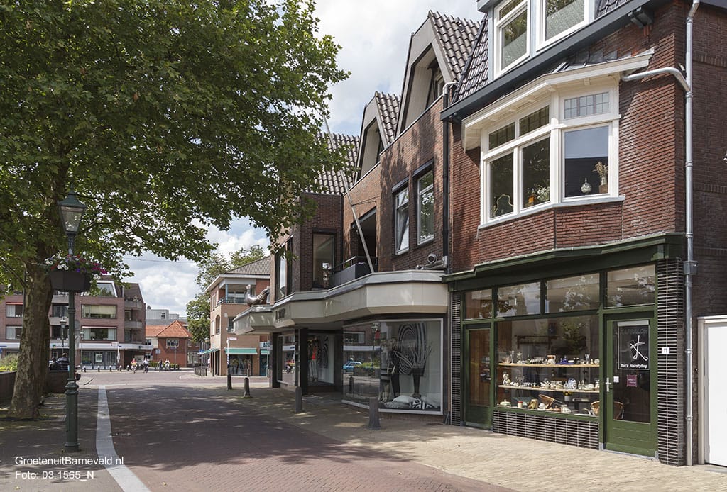 Heden, 2014 - Van links naar rechts: Appartementen complex met beneden ABN AMRO, Schoutenstraat, American Jeansshop, Modehuis Klomp en Ton's Hairstyling. - Barneveld