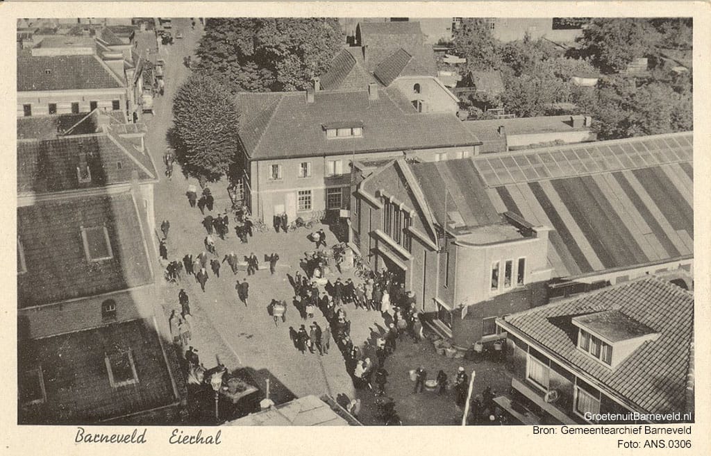 Verleden 1940/1955 - De markthal van 1930 en de markthal van 1913 (links) gefotografeerd vanaf de toren van de Grote Kerk. Rechtsonder modehuis Klomp, middenachter smederij Van der Mheen. - Barneveld
