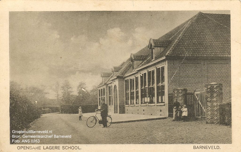 Verleden tussen 1920 en 1930 - Openbare lagere school. De foto is gemaakt in de richting van de Amersfoortsestraat. Deze verbindingsweg stond destijds bekend als het Tweede Achterdorp, Barneveld